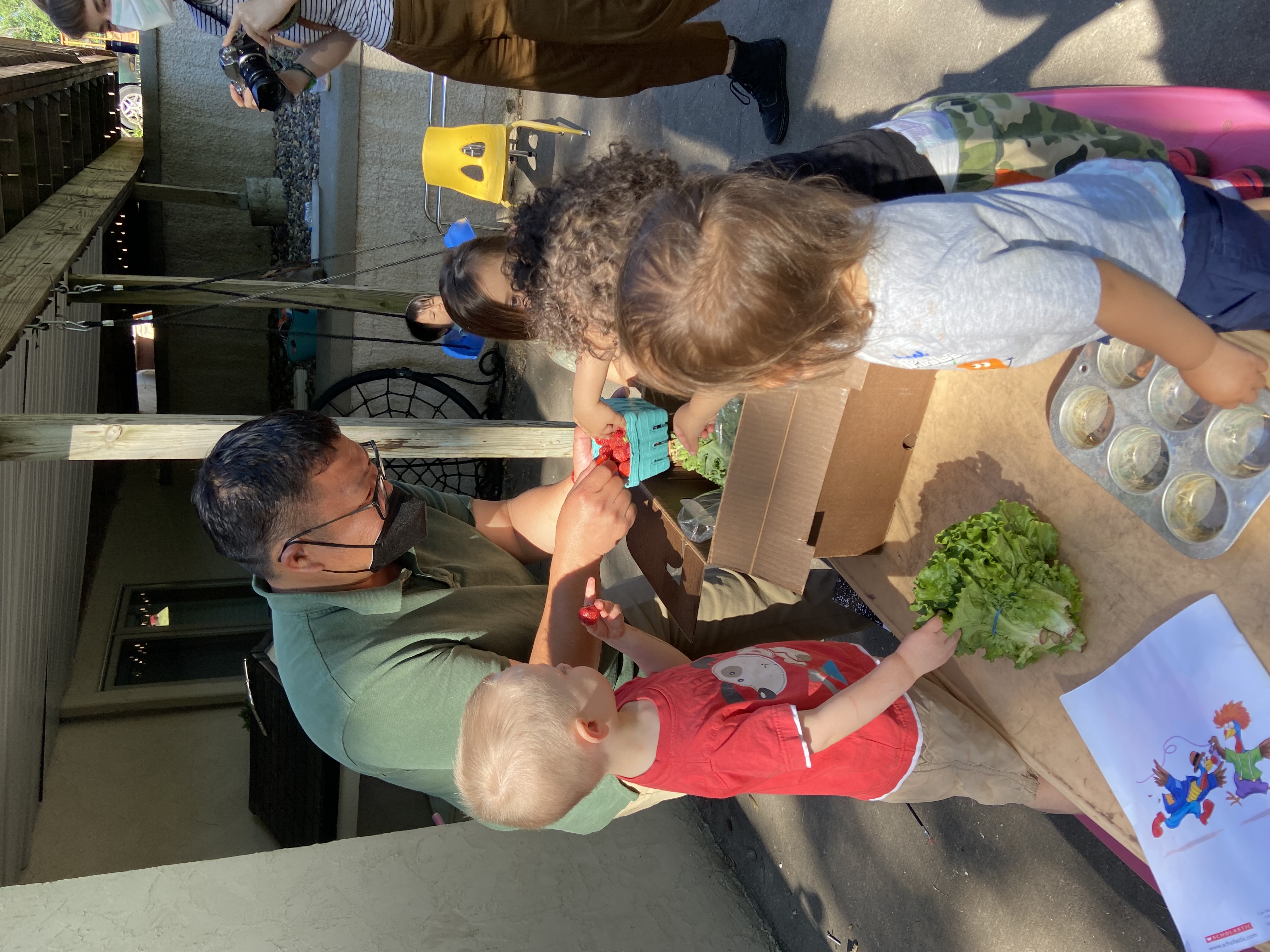 Janssen Hang unpacks CSA box with Early Care children