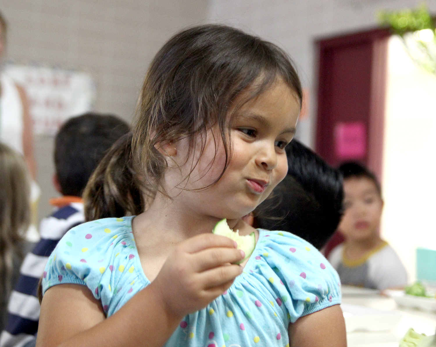 Roseville girl eating a cucumber