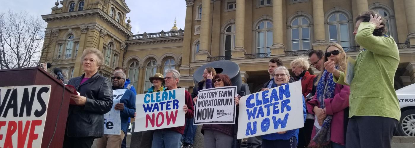 A crowd of anti factory farm advocates speaking outside the Iowa state capitol