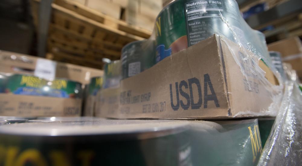 Cans on food aid shelf labeled USDA