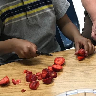 little kid cutting strawberries