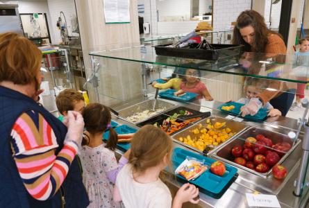 Children receiving local foods in a school cafeteria.
