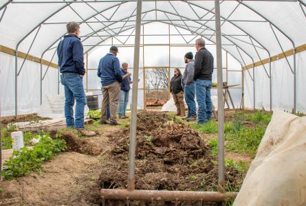 Farmers gathered in a hoop tunnel 