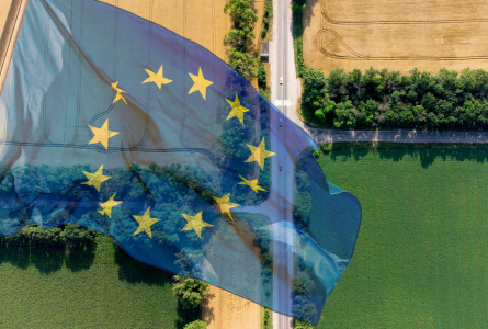 Aerial view of farm fields and road with EU flag overlaid